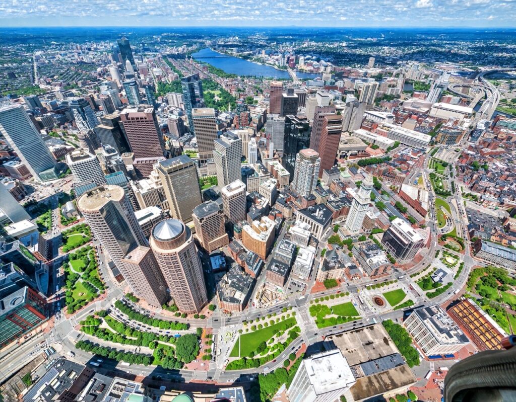 Aerial view of Boston, showing buildings, the river, and the Greenway - a park running through downtown.