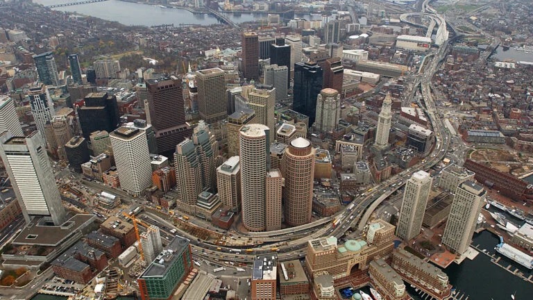 Aerial view of Boston in before the "Big Dig". Views of the city buildings, river, and highway are visible.