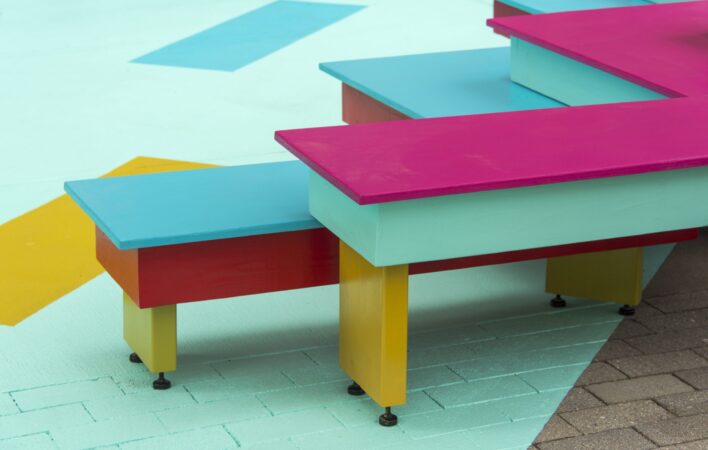 pictures of YEAR OF THE TIGER by Cheryl Wing-Zi Wong in Mary Soo Hoo Park on The Greenway. A multi-colored installation, the work features two sets of tiered and brightly colored zig-zag seating facing each other and a large teal ground mural.