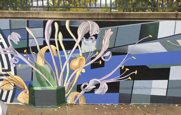 The picture shows a section of a mural featuring faded plant forms on a grayscale grid background. The sidewalk below and a metal railing on top of the mural illustrate the urban landscape.