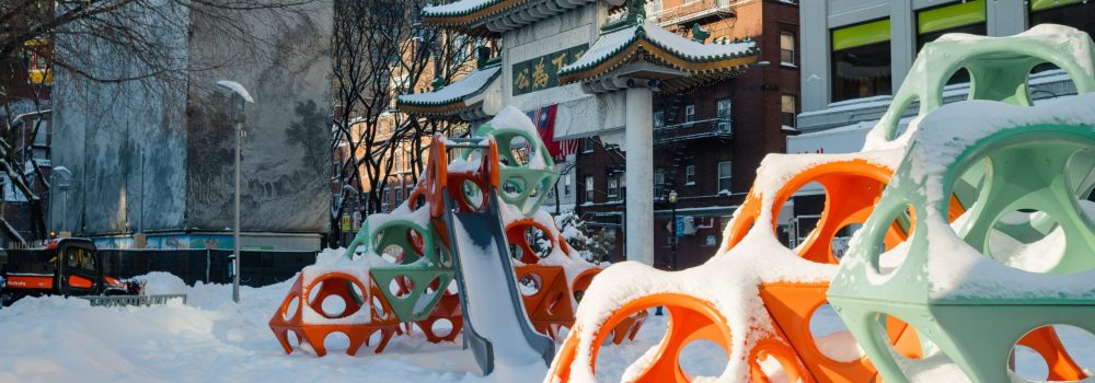 The Greenway's Play Cubes in Chinatown covered in snow, with the Chinatown Gate visible in the background