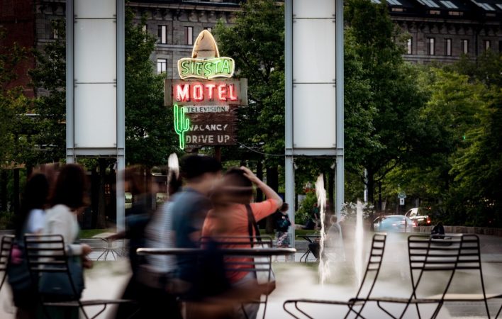 Always  a lot of people scurrying about on the greenway - especially around the rings fountain. In the background is the Siesta Motel sign, which dates back to about 1950, and was orignally from Saugus MA.